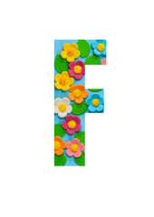 The letters F of the English alphabet is cut out of flowers on a blue  background.Floral pattern, texture for stores,sales,websites,postcards and holiday greetings.