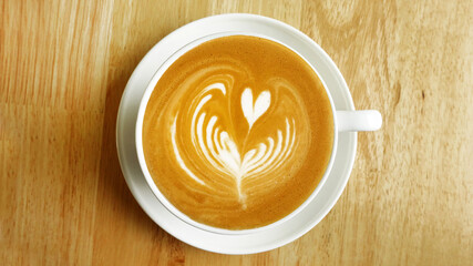 a cup of latte art coffee on wooden background                                                                                                                             