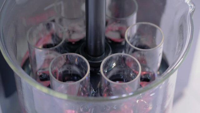 Close up: automatic tablet tester for measuring disintegration time of tablets, capsules - slow motion. Automated technology, healthcare, manufacturing, pharmaceutical, laboratory equipment concept