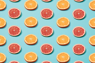 Slices of orange and grapefruit on a blue background. Minimal pattern.