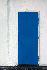 a blue metal door set in a concrete wall