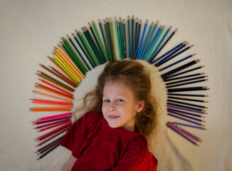 emotional girl lying on the floor with colored pencils, selective focus