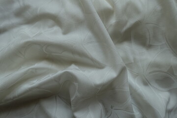 Crumpled thin white  polyamide fabric with floral pattern