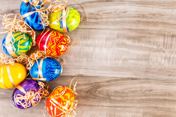 Colorful Easter banner with Easter Egg on wood background. Above view with copy space.