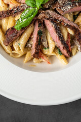 With sliced ​​grilled meat on a creamy penne pasta.