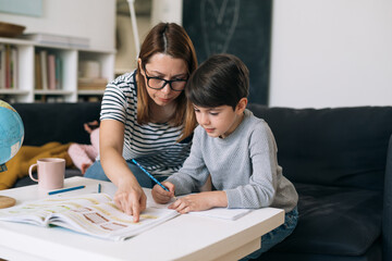 Obraz premium mother helping her son to do homework