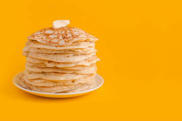 Staple of yeast fluffy pancakes with butter. Spring holiday Traditional Russian Shrovetide Maslenitsa week or pancake tuesday holiday. american crepes isolated on yellow background