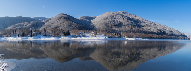 Winter mountain landscape. Beautiful panoramic view of frozen lake and mountains.