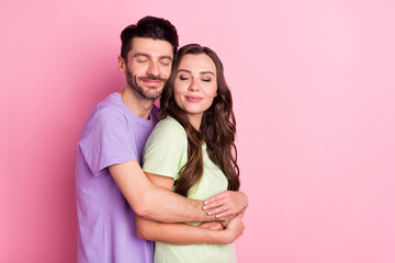 Portrait of attractive dreamy cheerful couple embracing amour sweetheart isolated over pink pastel color background