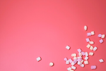 Marshmallows on the pink background, with free space for text. Top view, colorful flat lay. Beautiful background for birthday, holiday cards, for banners. Template for social media.