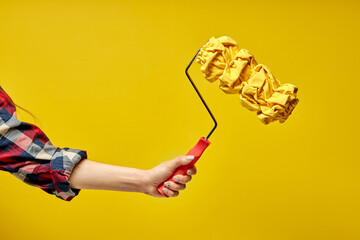 Textured roller for wall painting in hands of female