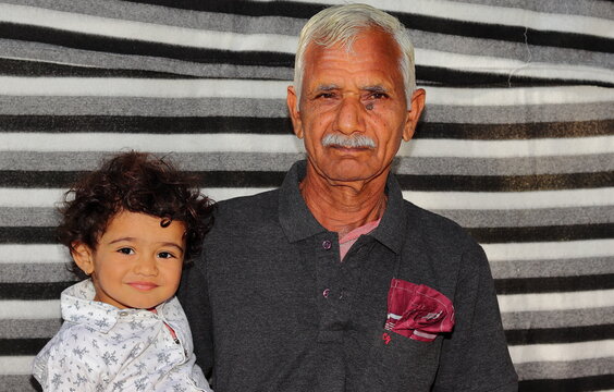 Portrait photo of an indian senior happy grandfather and younger grandson together, India