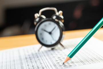 alarm clock, optical form of standardized school test with bubble and black pencil, answer sheet, education concept