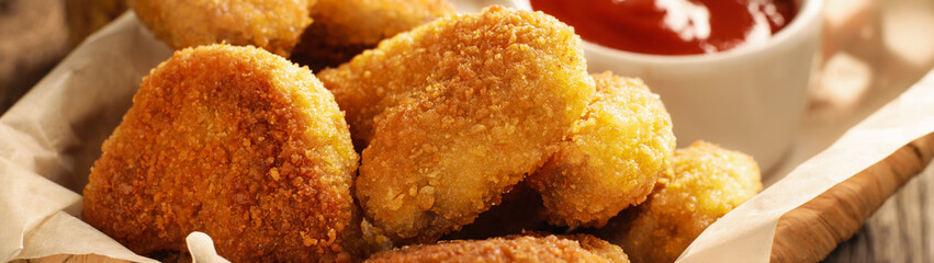 Close up of chicken nuggets in basket and chili tomato sauce banner