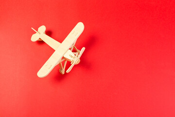 wooden model of a passenger plane with on a red background. tourism and travel