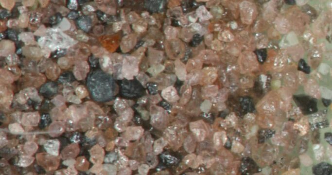 fine sand with quartz crystals under a magnifying glass