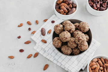 Homemade energy balls made from dried fruits and oatmeal. Healthy food, snack. Vegetarian, vegan raw dessert. Energy balls and ingredients nearby on a gray background. View from above