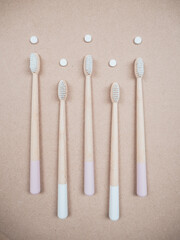Bamboo toothbrush and dental tabs on a wooden background, plastic free alternative
