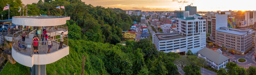 Aerial photo of peoples using facemask on tower platform photographing and watching sunset 
