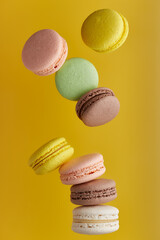 Macaroon. Colorful cake macaron with pastel tones fall at the stack macaroon on an yellow background. Top view of almond cookies.