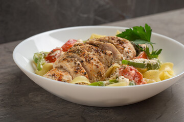 A view of a plate of cajun chicken Fettuccine pasta in a creamy sauce. American cuisine.