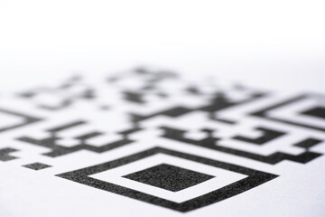 QR code printed on paper. Macro image. Focus on the bottom of the code, blurred gradient