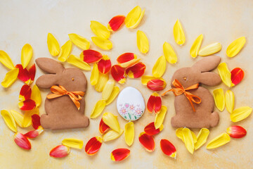 Easter Background. Easter  bunny biscuits, egg sugar cookie and yellow and red petal background....