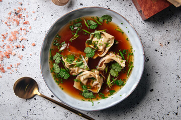 Top view on asian meat stuffed dumplings with bouillon in a bowl