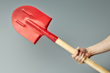 Big Red shovel with wooden handle isolated on gray
