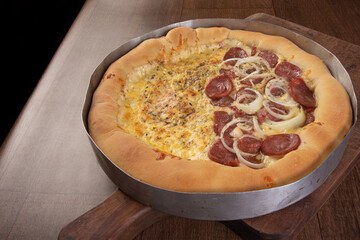 Pizza, homemade pizza half of mozzarella and half of pepperoni with onion on a table, black background, selective focus.