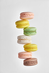 Macaroon. Colorful cake macaron with pastel tones not evenly stacked in a row on white background. Top view of almond cookies.