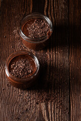 Obraz na płótnie Canvas Homemade dark chocolate mousse in rural jars on rustic wood table