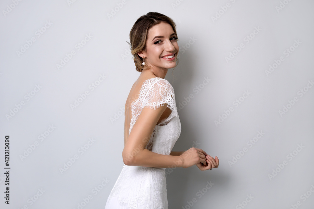 Poster young bride with elegant wedding hairstyle on light grey background