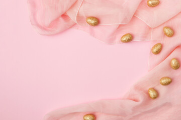 Minimal layout golden Easter eggs on a pink fabric background with copy space.