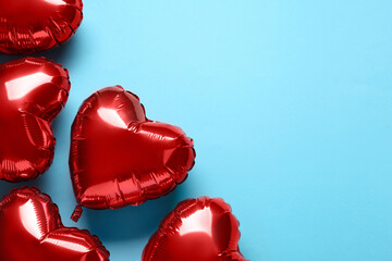 Red heart shaped balloons on light blue background, flat lay with space for text. Valentine's Day...