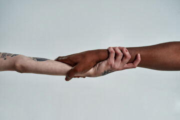 Multiracial couple holding hands in lock shape - obrazy, fototapety, plakaty