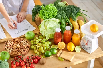 Poster Young Dietitian writing diet plan, view from above on table with different healthy products © Roman