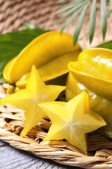 Delicious carambola fruits on light grey wooden table