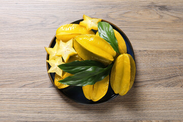 Delicious carambola fruits on wooden table, top view