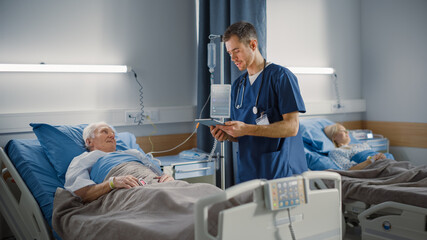 Hospital Ward: Friendly Male Nurse Talks Reassuringly to Elderly Patient Resting in Bed. Doctor...