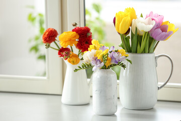 Different beautiful spring flowers on window sill