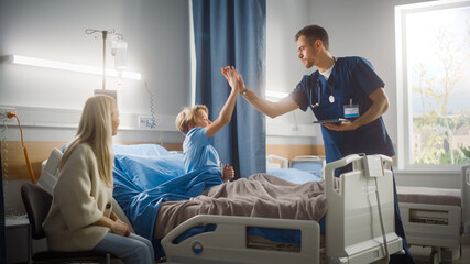 Hospital Ward: Handsome Young Boy Resting in Bed with Caring Mother Visits to Support Him, Friendly...
