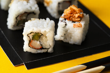 Rolls texture. Close up of Japanese Avocado And Crab-Meat Rolls topping with crunch onion on bright background.