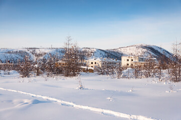 Fototapeta na wymiar Abandoned apartment buildings in the ghost town Kadykchan, famous for coal mines, Kolyma, Magadan region, during sunny winter day