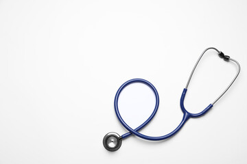 Stethoscope on white background, top view. Space for text