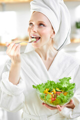 Joyful Caucasian Lady Tasting Vegetable Salad Enjoying Healthy Breakfast In Modern Kitchen At Home