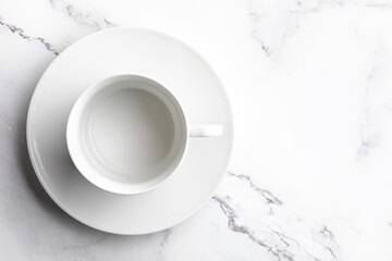 Empty white ceramic bowl on white marble background.