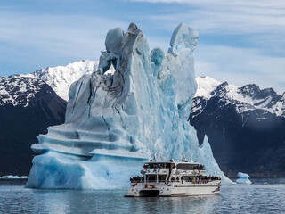 High icebergs and catamaran float in the Lago Argentino, El Calafate, Argentina.