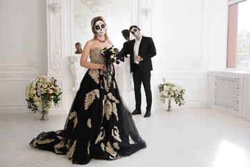 A couple with skeleton make up for Halloween or All Souls Day