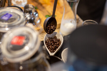 Spoon the coffee beans in a small cup on the barista's table.
